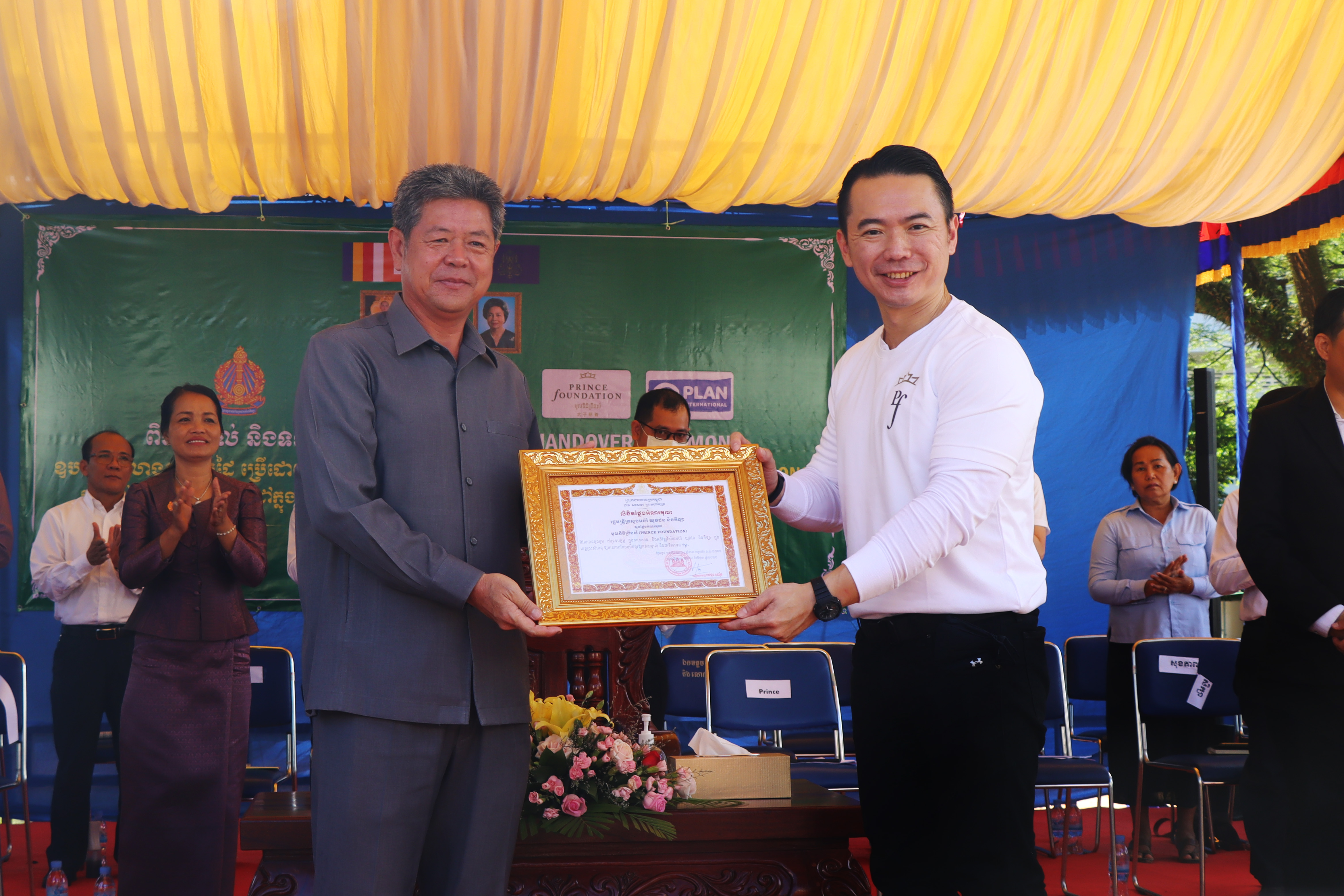 Mr. Gabriel Tan (right) receiving the letter of appreciation from H.E. Kouch Chamroeun (left)
