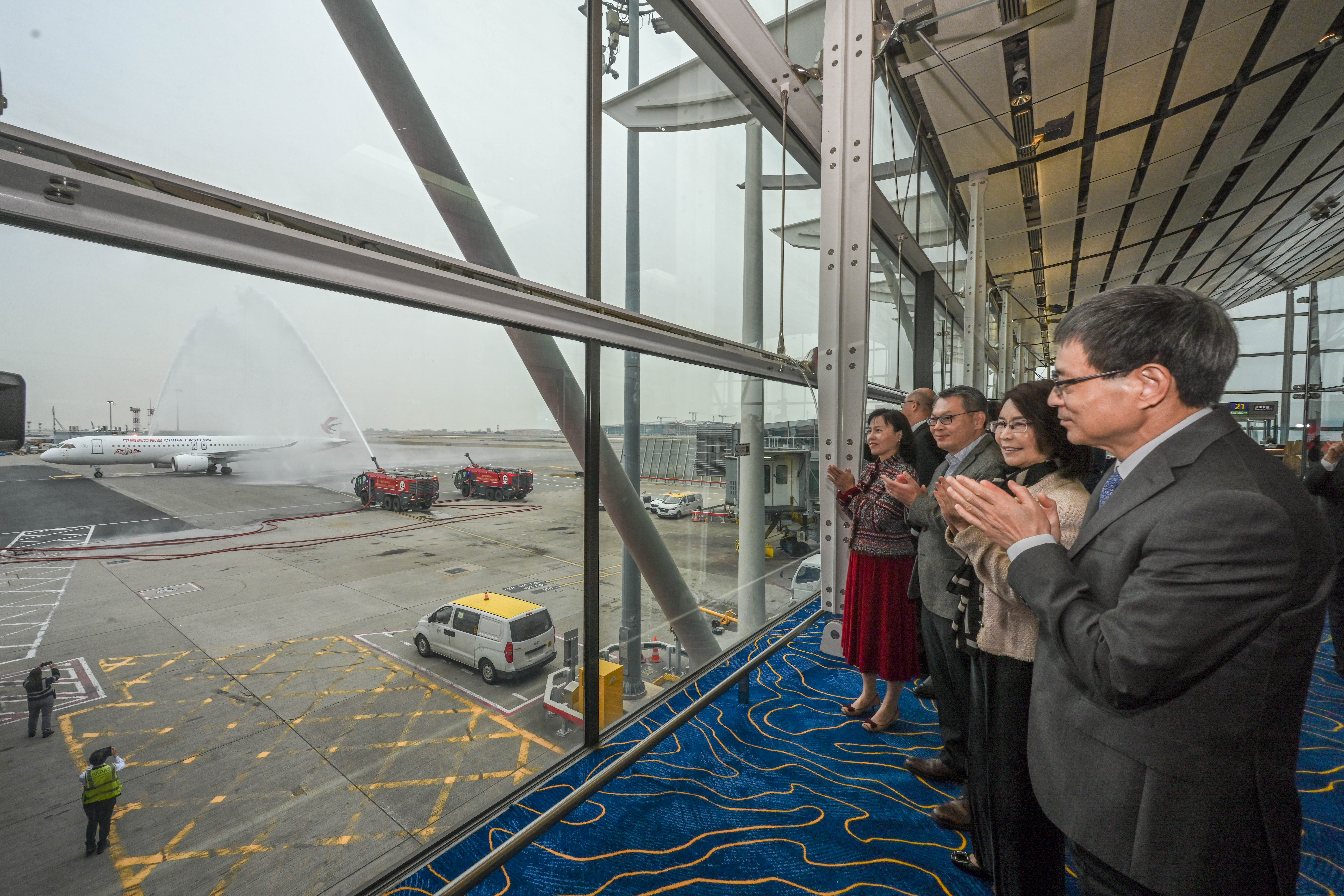 The C919 aircraft receives a water salute at Hong Kong International Airport and warm welcome by Secretary for Transport and Logistics Mable Chan (first left).