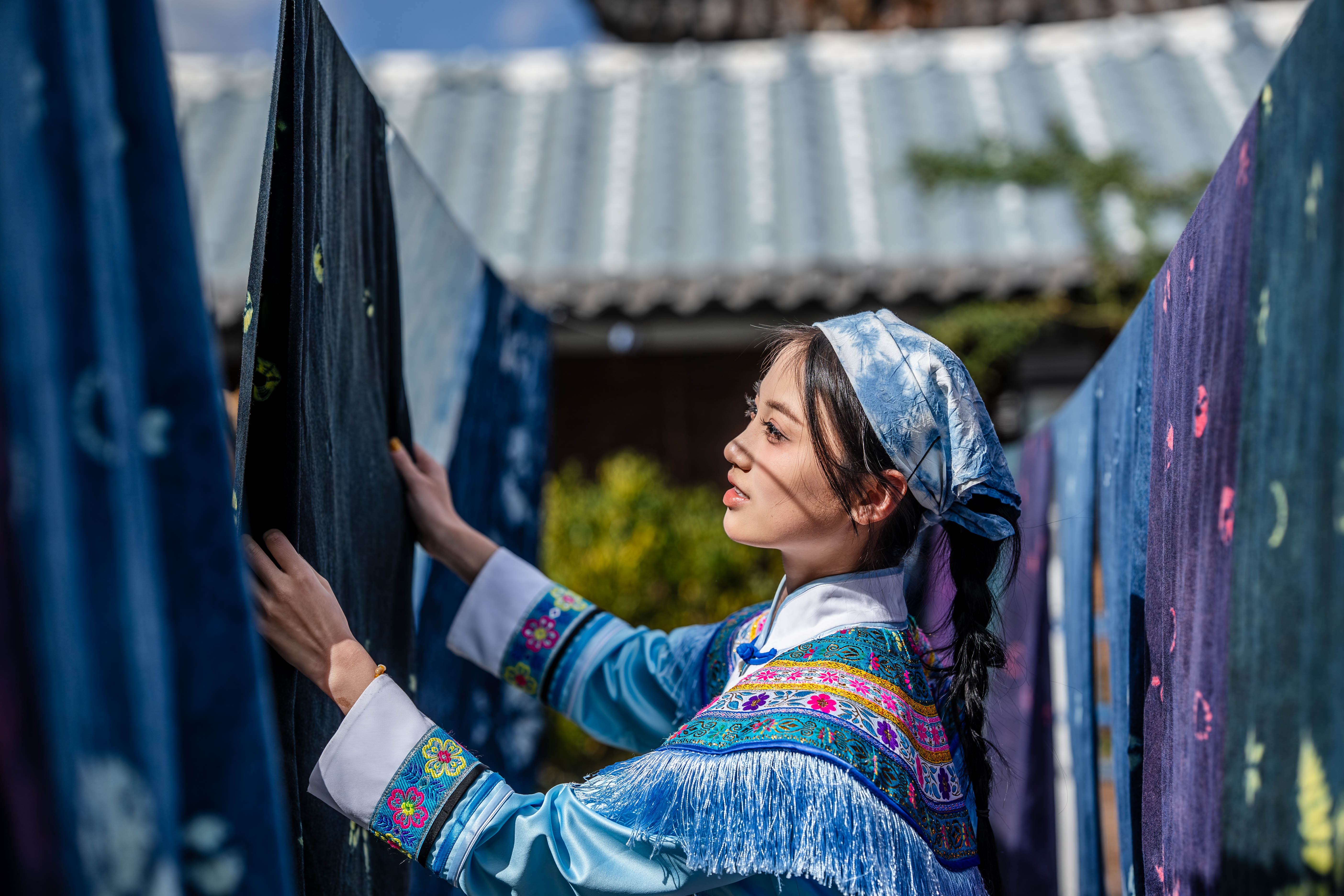 Caption: A woman experiences the tie-dye technique of Bai ethnic groupin a dyehouse in Zhoucheng Village of Dali Bai Autonomous Prefecture, southwest China
