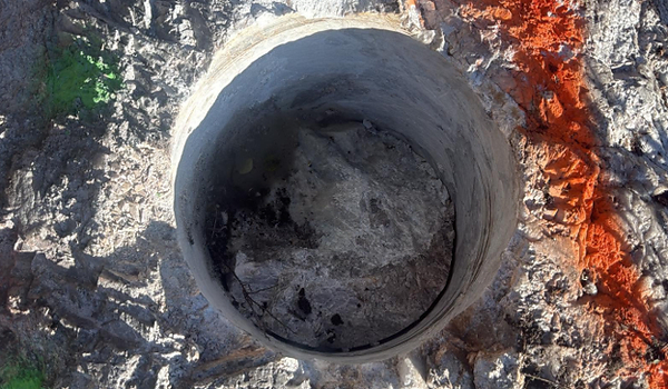 Figure 2: (TOP) Cored drill hole (~30 cm diameter) in pollucite pegmatite outcrop; (BOTTOM) Grid of cored drill holes (~30 cm diameter) in pollucite pegmatite outcrop (see Table 1). Segments between holes are jackhammered out and added to sample composite.